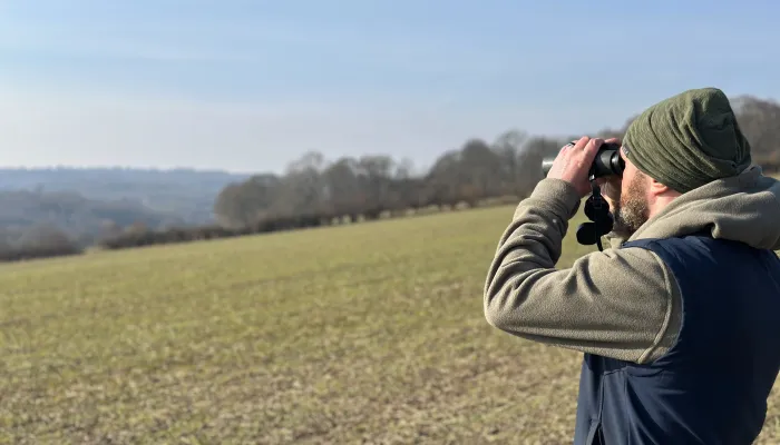 Hoathly Farm image man looking at landscape with binoculars 